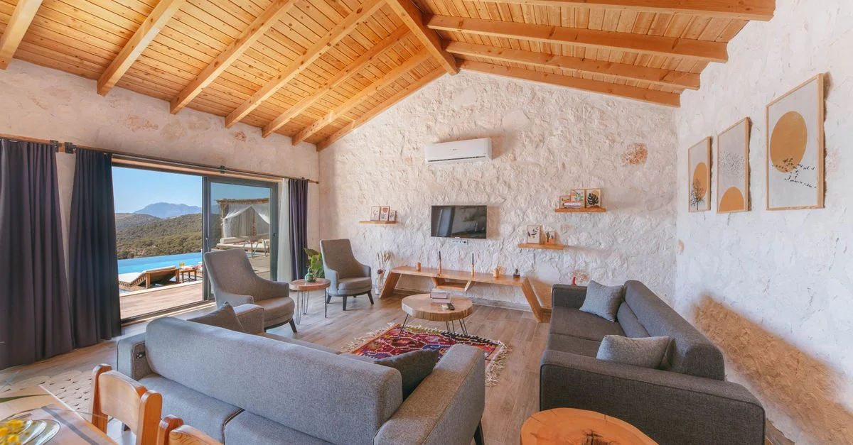 Salon chaleureux avec un plafond en bois et une vue extérieure pittoresque.