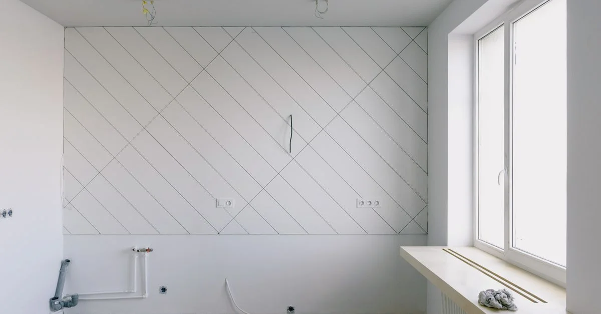 Pièce moderne avec des matériaux de rénovation, y compris des câbles et un sol en bois, baignée de lumière naturelle grâce à la fenêtre.