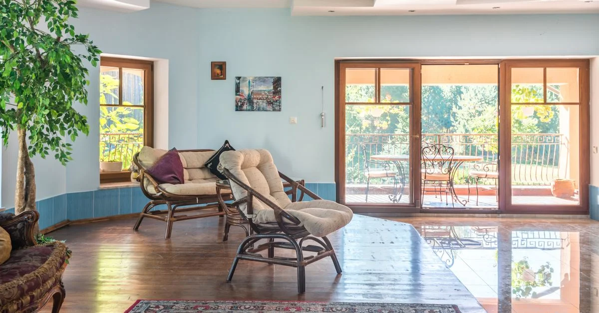 Salon spacieux avec un intérieur moderne et vue sur le balcon de jardin ensoleillé.