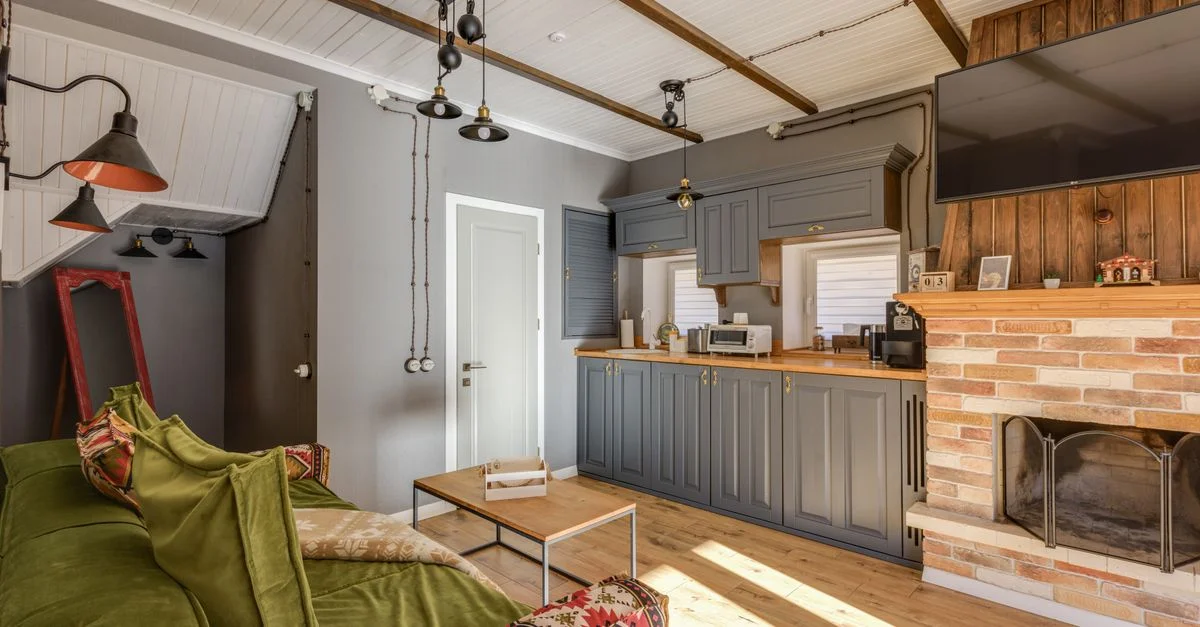 Salon chaleureux et confortable avec cuisine, présentant une cheminée et des éléments de design contemporain.