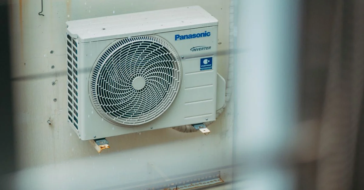 Unité de climatisation montée à l'extérieur sur un mur de bâtiment, montrant la technologie HVAC moderne.
